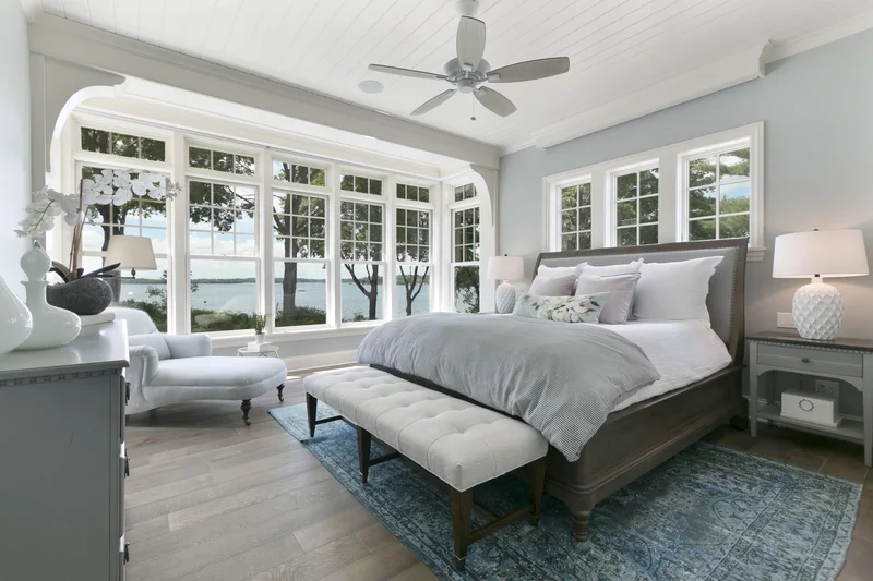 Spacious bedroom with light blue painted walls and white trim