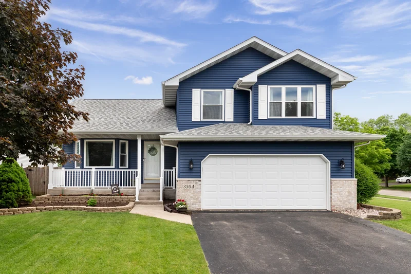 Professional exterior house painting with blue siding and white trim.